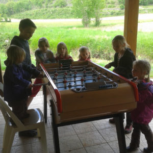 Partie de baby-foot entre enfants au camping