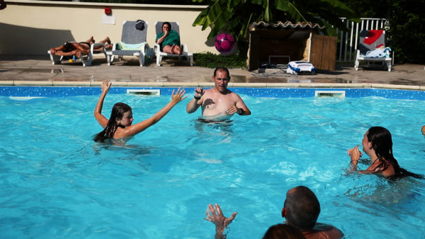 Jeux aquatiques d'une famille à la piscine du camping