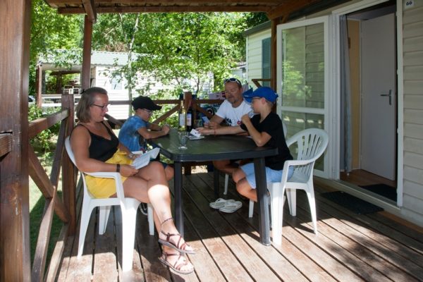Moment famille sur la terrasse en bois d'un mobil'home 6 personnes
